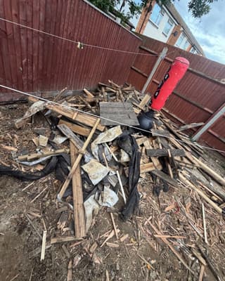 Before: a heap of broken up decking in a back garden