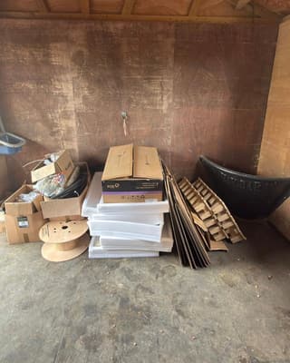 Before: boxes, a cable reel and flat cardboard stacked inside a stable
